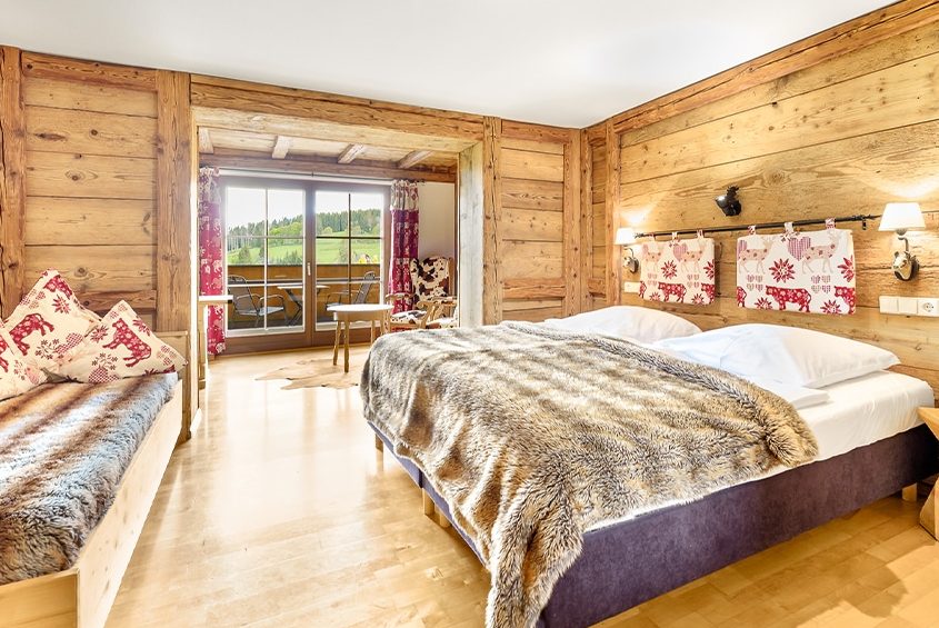 Gemütliches Doppelzimmer mit kleiner Sitzecke und Balkon mit Aussicht in den Schwarzwald im Hotel Schlehdorn der Kategorie Hüttenstil Deluxe